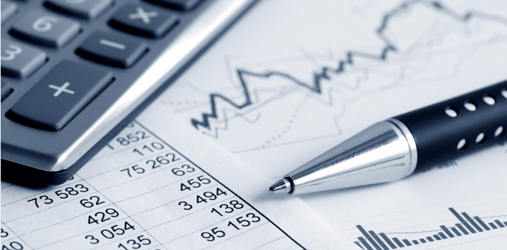 Calculator and pen on financial forecasting figures