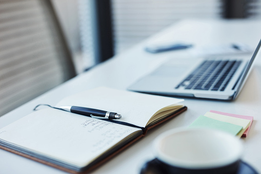 Notebook, pen and laptop on a desk